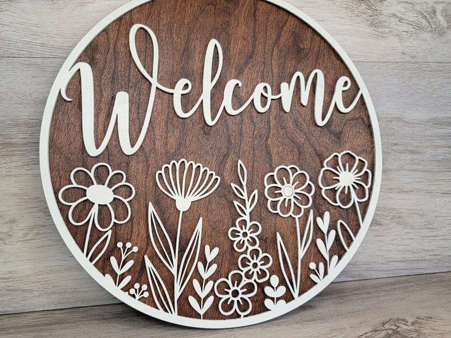 Layered laser-cut wood welcome sign with floral design