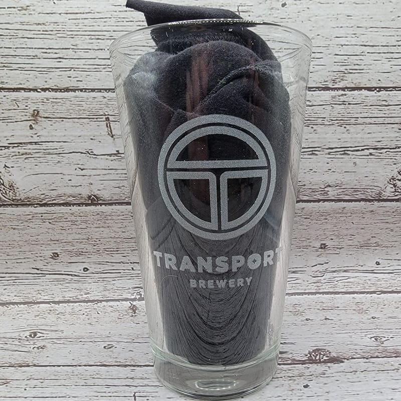 Laser-etched pint glass with the Transport Brewery logo and wordmark